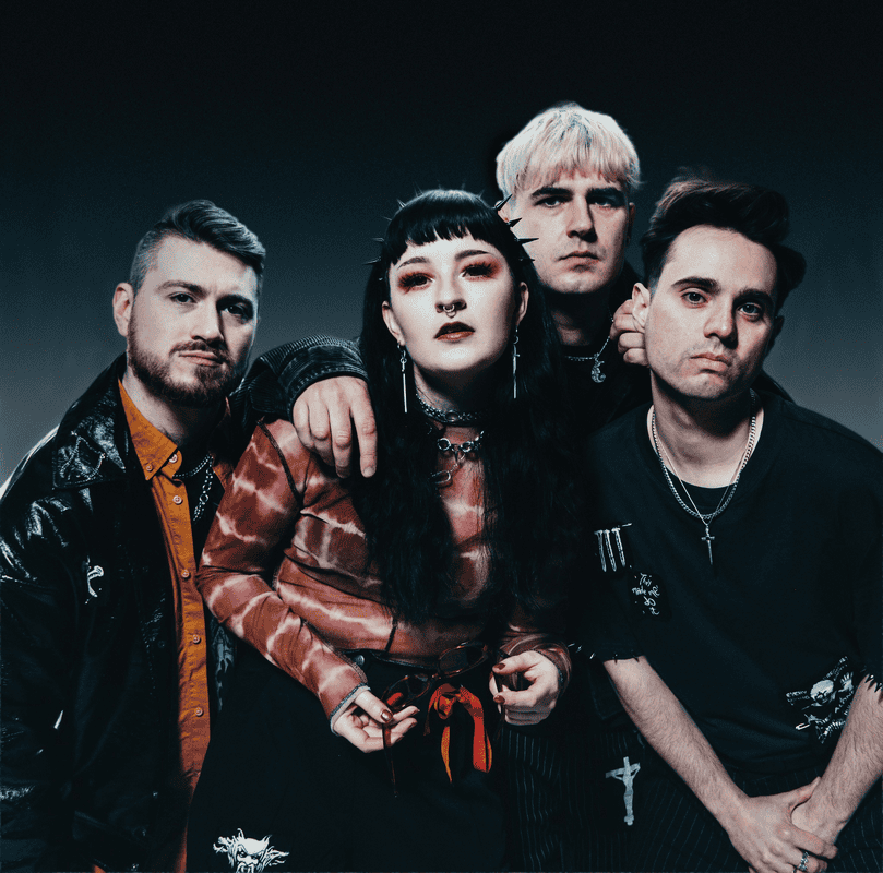 Four members of a rock band pose together, moody lighting and punk style outfits create a bold group portrait.