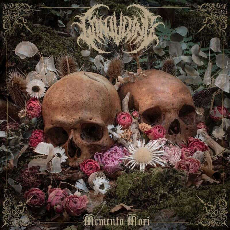 Two human skulls nestled among pink and white flowers in a dark, ornate, gothic still-life with moss; caption reads 'Memento Mori'.