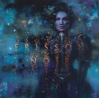 Album cover: a woman in a blue, smoky scene with glowing sparks forming the word 'FRISSON' across her torso.